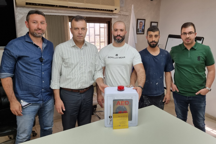 Members of the community of Nahef receiving the defibrillator from the Rabia Salama (left), along with the head of the local council and Firas’s brother, Karim (center). Photography: Rambam HCC.