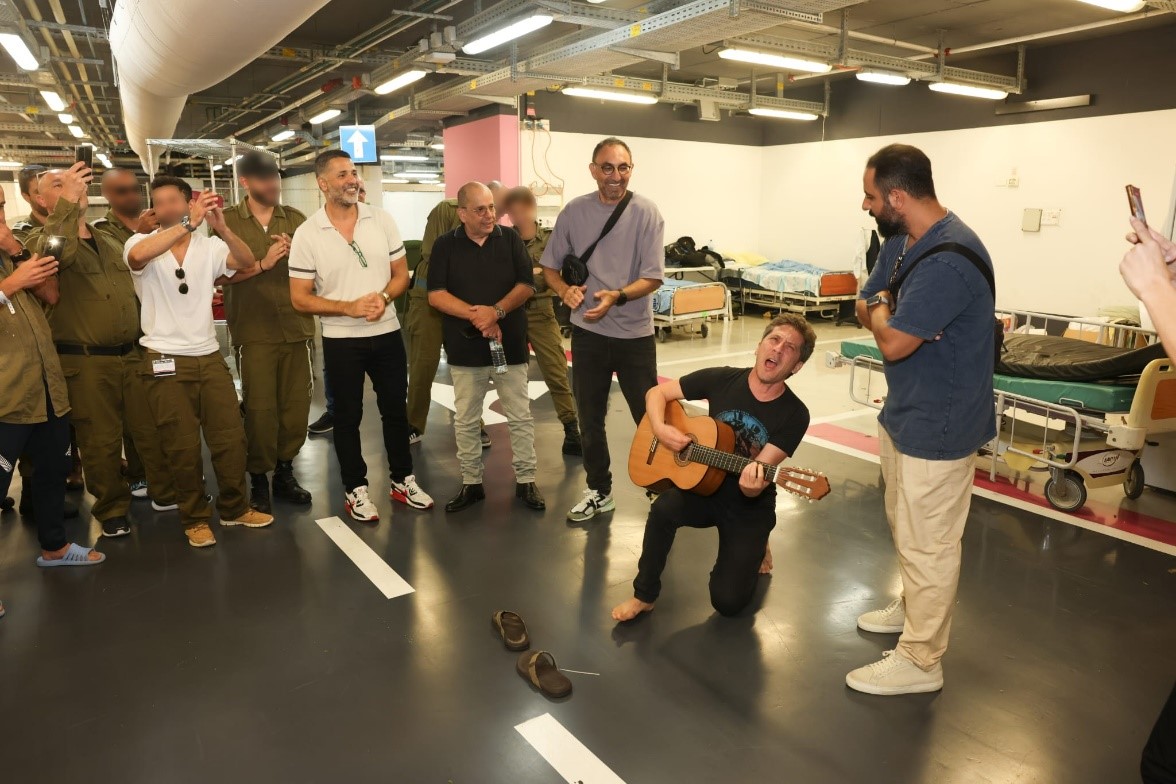 Idan Alterman singing for soldiers and staff in the underground hospital. Photography: Rambam HCC.