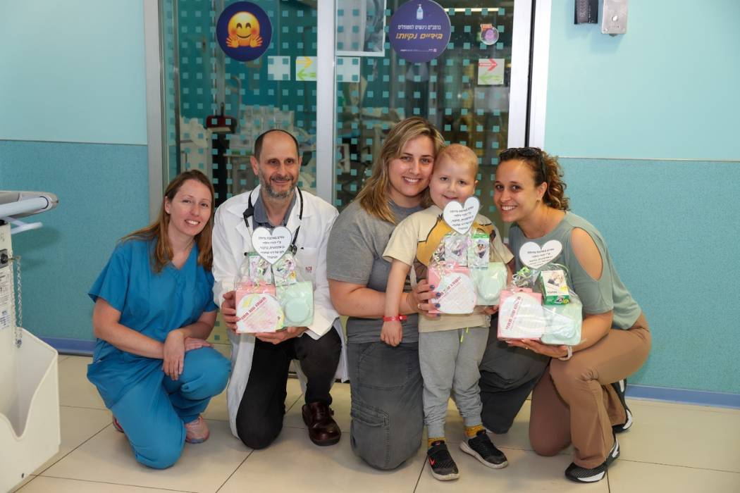 בתמונה: רני עדן-שחורי ברמב"ם.  בתמונה: הענקת ערכות הצילום מילדי גן "אדמונית" לצוות רמב"ם. מימין לשמאל: אור לרדו ממן, גננת גן "אדמונית", רני עדן-שחורי, ואמו דנה, ד"ר רוני גפן ויאנה דיאמנד, מצוות השתלות מח עצם ילדים ברמב"ם. צילום: הקריה הרפואית רמב"ם.