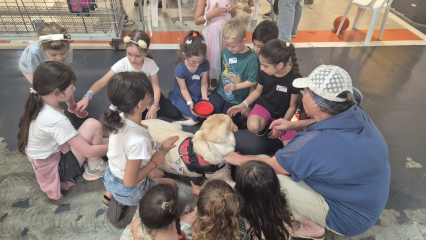 Children at Rambam's fortified daycare center enjoy a moment with Tinka and her trainer, Idit Leiber (far R)