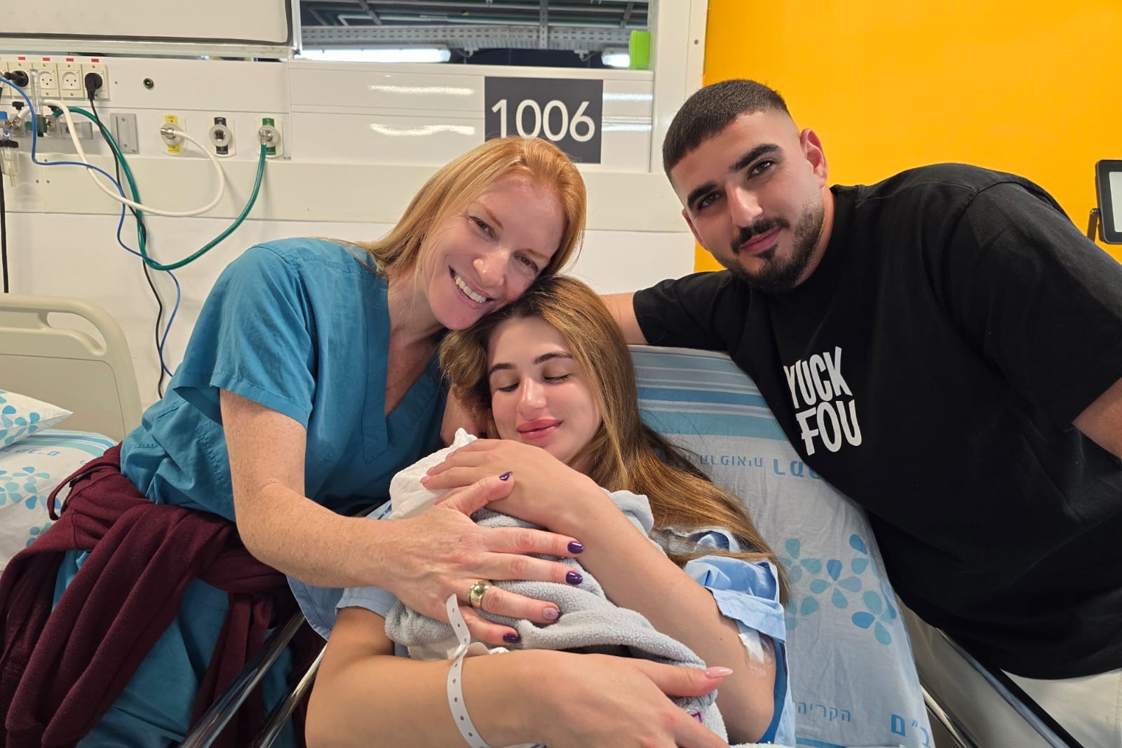בתמונה: יובל וירין חזות עם בנם הבכור - התינוק הראשון שנולד בבית החולים התת קרקעי ברמב"ם, והמיילדת חן תורג'מן | צילום: דוברות רמב"ם.
