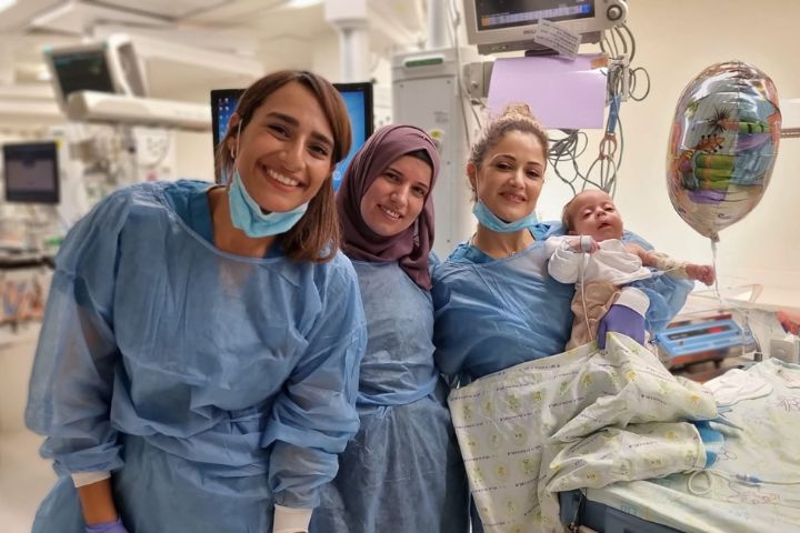 Marwa Majeli with her son in the arms of one of the nurses from the Department of Neonatology and Neonatal Intensive Care. Photography: Rambam HCC.